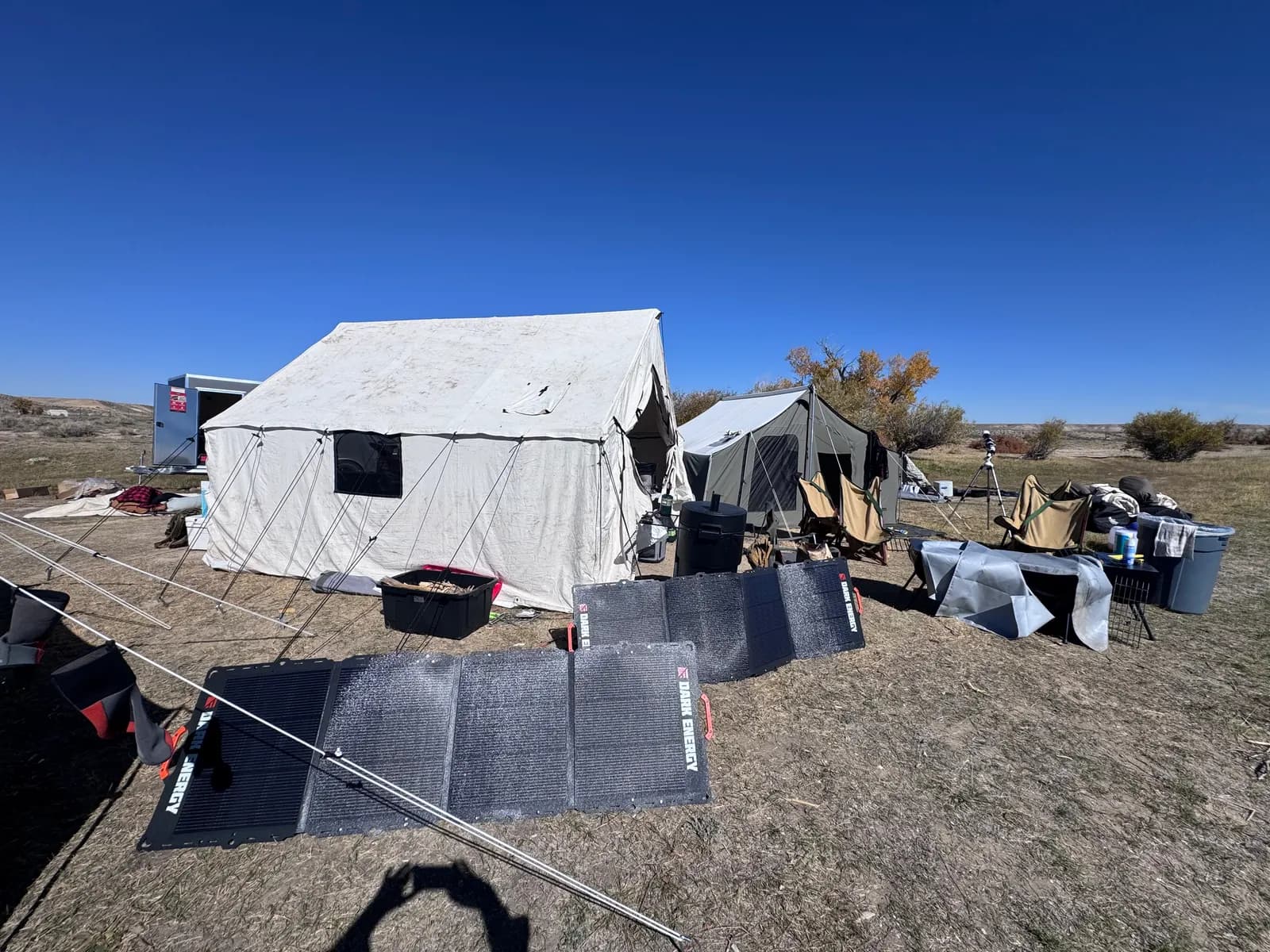Dark Energy solar panels laid out in front of a canvas wall tent.